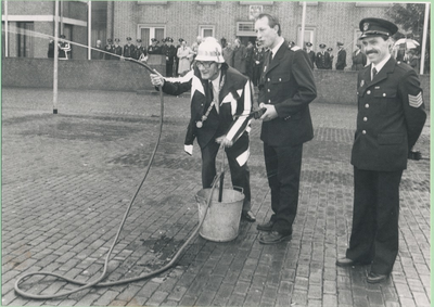 Burgemeester Roels blust, als burgemeester, het laatste brandje in Someren, met geheel rechts Joep Linden van de brandweer