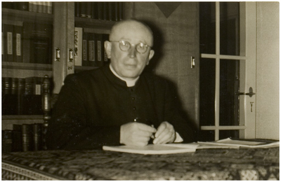 Pastoor J.van Dal, [Lierop] van de Parochie van de Heilige Naam Jezus in Lierop, in zijn werkkamer