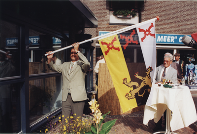 Het plaatsen van de gemeentevlag aan de voorgevel van het VVV door wethouder Toonders