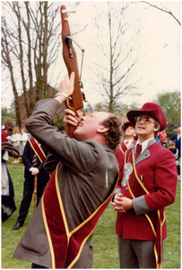 Carnaval. Wedstrijden koniningsschieten, Zaterdag 25 april 1981. Burgemeester Wouters lost onder het toeziend oog van hoofdman van Olmen het eerste schot op de koningsvogel