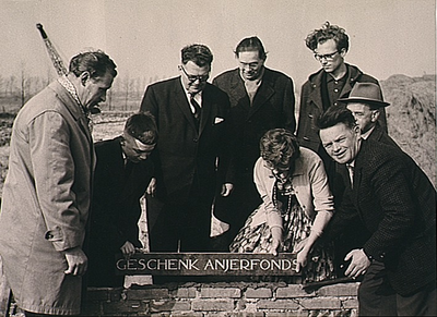 De 1ste steenlegging van kunstenaarsatelier Genderpark, met de gedenksteen Geschenk Anjerfonds. eerste steenlegging kunstenaars Anjer-atelier