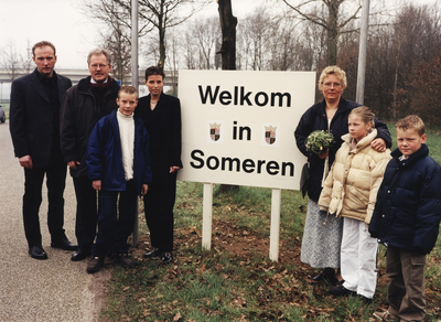 Gezinsfoto van de familie Veltman bij het welkomstbord van hun nieuwe gemeente Someren