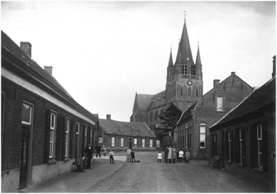Inwoners poseren voor de foto, R.K. kerk H. Willibrodus gezien vanaf de Heuvel