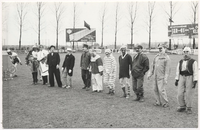 Carnaval 1965. Gekostumeerde voetbalwedstrijd aan de Bakelsedijk. Enkele spelers opgesteld, 3e van links, (met bolhoed) is Dhr.van Berlo