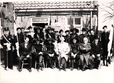 Schutters van Gilde Sint Joris voor café F. Rijntjes van Dijk, in de lichte jas, vooraan zittend, Burgemeester Ploegmakers. Links onder de deurstijl Harrie van Goch