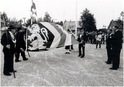 Viering 800 jaar Hoogeloon, Hapert en Casteren.Onthulling, gehouden op het Valensplein te Hoogeloon. De nieuwe vlag wordt getoond aan de commisaris der koningin, mr. A.M. van Agt. Rechts op de foto mr. V. Agt en burgemeester H.J.L. Wouters. Links op de foto de hoofdman der gilde St. Sebastiaan, Piet v.d. Pas