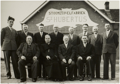 Liessel. 50 jarig jubileum Stoomzuivelfabriek  St. Hubertus  te Liessel. Zittende v.l.n.r. : P. Beks ( president R. v. T. ), pastoor van Kemenade ( G.A. ), J. Damen ( voorzitter ), A. Joosten ( vice voorzitter ), staande, v.l.n.r. : H. Aarts, Joh. Van de Mortel ( leden R.T. ), M. Krekels, Jol Jansen, H. Verbugt ( bestuursleden ), H. Hijbers ( directeur ), P. van Lieshout en A. Geboers ( leden ). Datum jubileum 26 november 1957