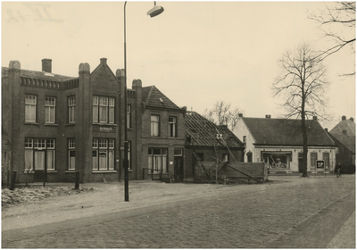 Provincialeweg ter hoogte van de Kapelstraat, van links naar rechts café Bushalte, de Greef, dokter Willemse, kapsalon Piet Lodewijks. Witte huis rechts familie Sweegers